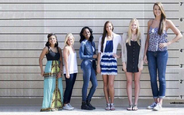 A photo of a group of women of different heights standing together